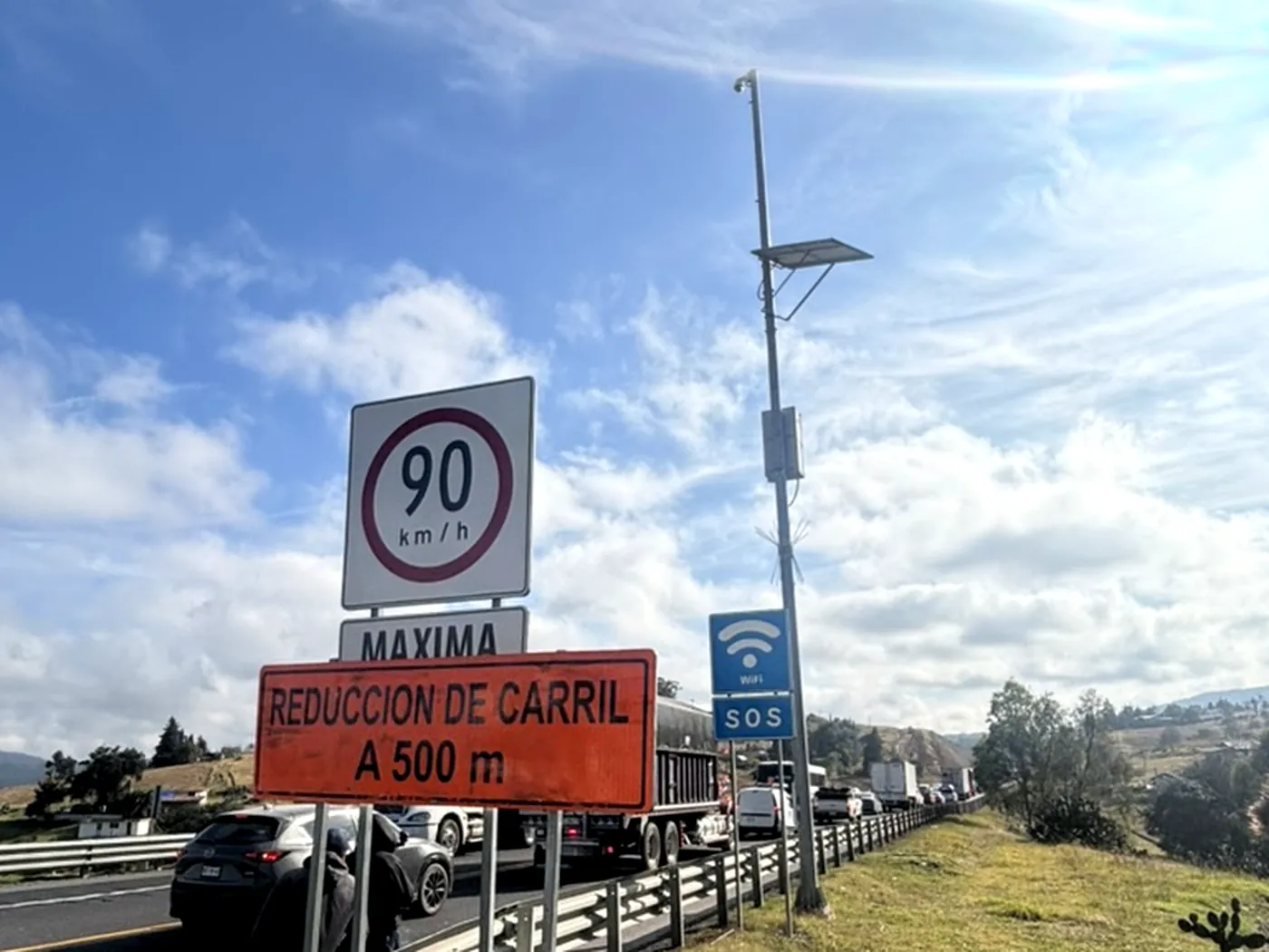 Mástil wifi junto al señalamiento vertical de una autopista mexicana con tráfico